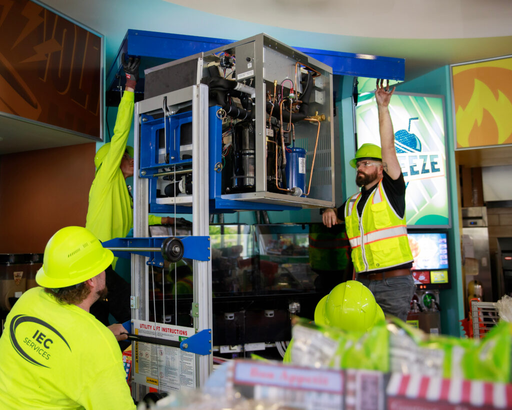 construction workers raising their hands and looking at a machine